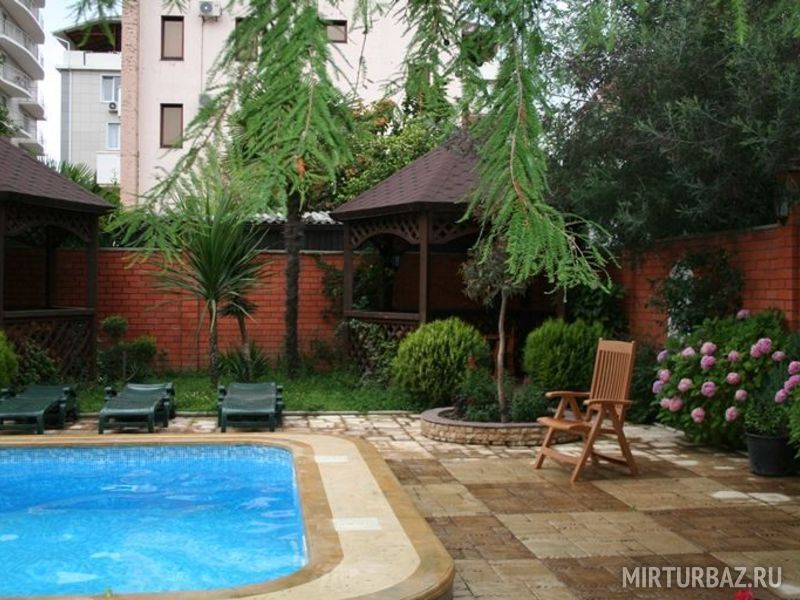 Бассейн окружен зеленью.