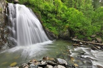 Потоки водопада Корбу разбиваются о мелкие пороги, приковывая взгляд